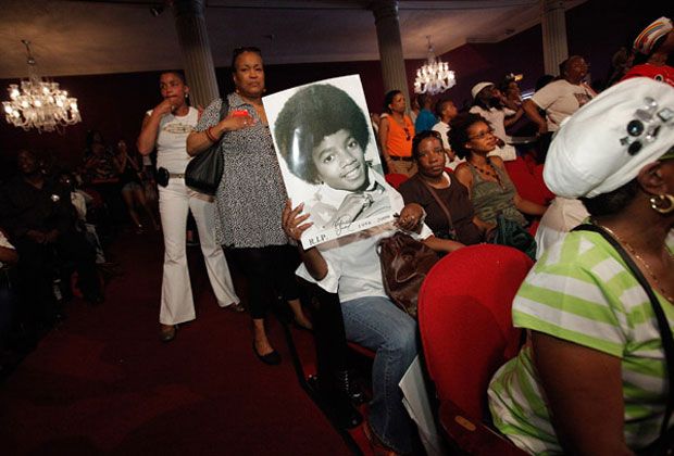 Fans hold old photographs of Michael Jackson